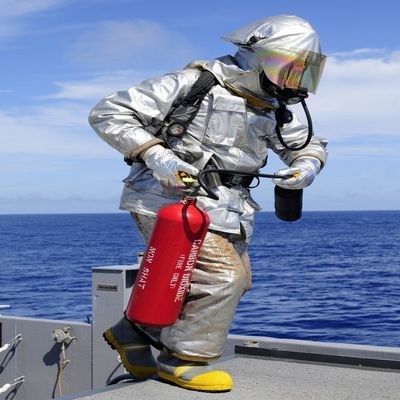 Posterazzi Firefighter carries a CO2 fire extinguisher onto the flight deck of USS Denver Poster Print, (24 x 33)