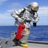Posterazzi Firefighter carries a CO2 fire extinguisher onto the flight deck of USS Denver Poster Print, (24 x 33) view 1