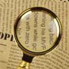 A Golden and Gold-Plated Gift with Reading and Newspaper Magnifying Glass in Hand view 3